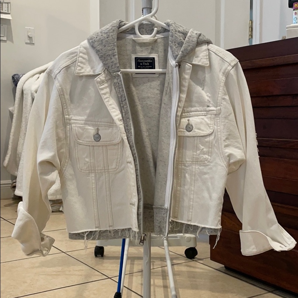 Women’s white denim jacket layered with a hoodie